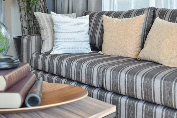 Moderno salón interior con almohadas a rayas en un sofá casual —  Fotos de Stock