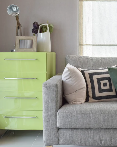舒适的沙发上，用几何图案枕头和绿色生活角餐具柜 — 图库照片