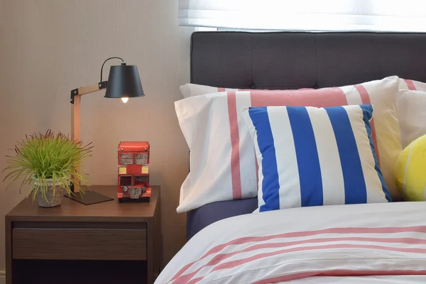 Nowoczesna sypialnia wnętrza kolorowy pasiasty poduszki i lampki drewniane — Zdjęcie stockowe