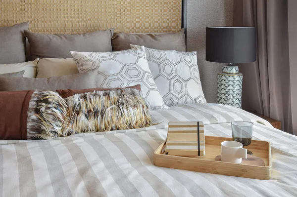 Стильный интерьер спальни с полосатыми подушками и декоративным чайным сервизом — стоковое фото