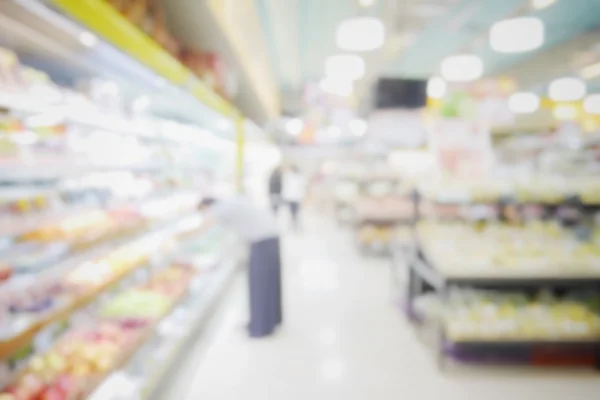 Verschwommener abstrakter Hintergrund von Menschen, die im Supermarkt einkaufen, mit verschiedenen Produkten im Regal — Stockfoto