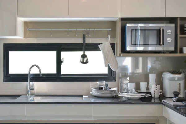 Keramik und Geschirr neben Spüle in moderner Küche — Stockfoto