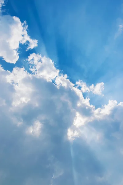 Moln på blå himmel med solstrålar Stockbild