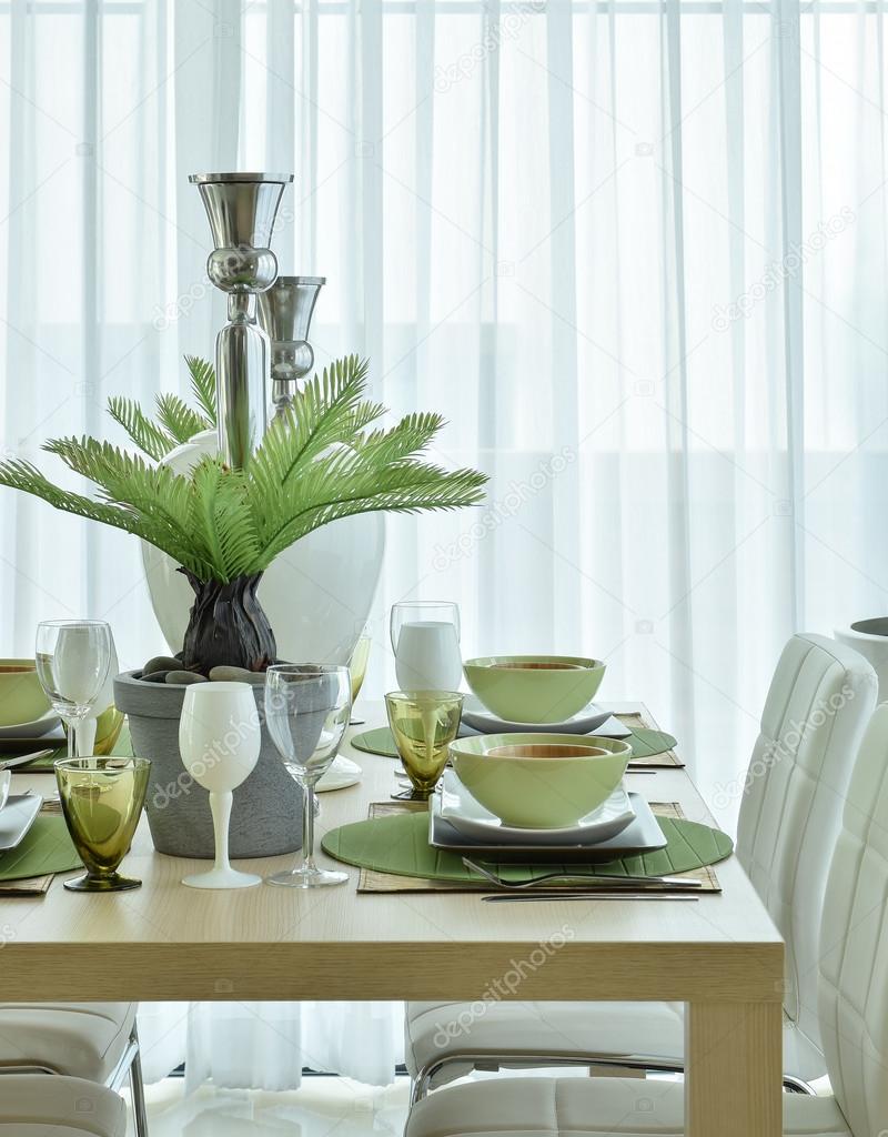 Beautiful modern ceramic tableware in green color scheme setting on dining table