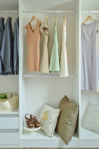 Мужская и женская одежда висит на вешалках в шкафу — стоковое фото