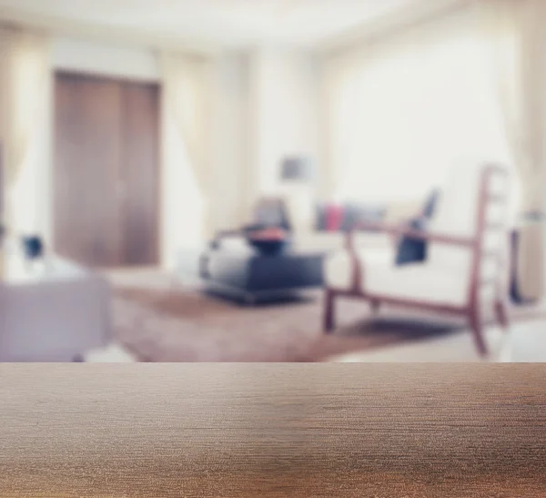 Wooden table top with blur of modern living room interior as background — Stock Photo, Image