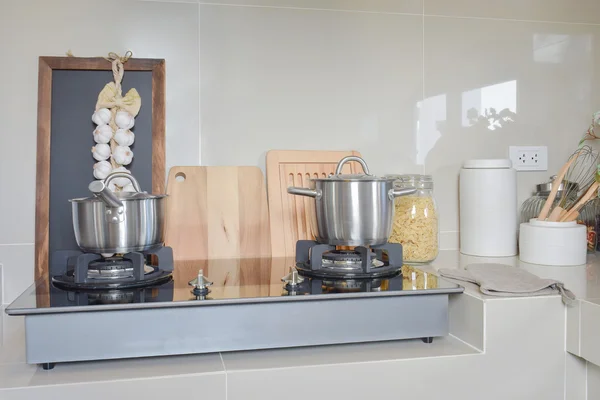 Panela de aço inoxidável no fogão a gás com utensílio na cozinha moderna — Fotografia de Stock