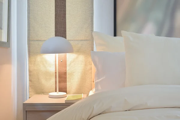 Acogedor dormitorio interior con almohadas y lámpara de lectura en la cabecera t — Foto de Stock