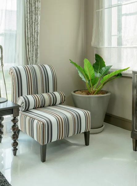 Elegante interior de la sala de estar con almohadas de patrón rayado en el sillón — Foto de Stock