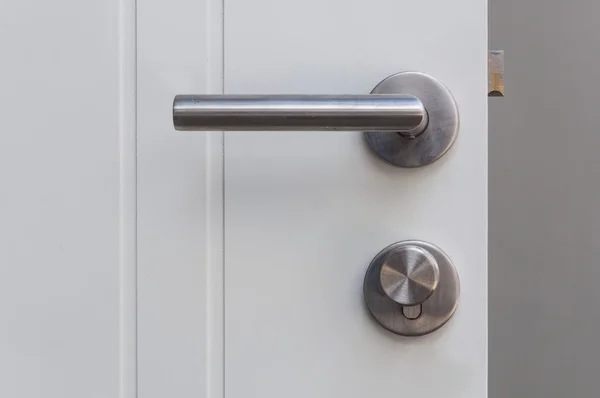 Aluminium door knob on the white door — Stock Photo, Image