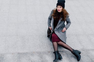 Sokakta oturan genç kadın.