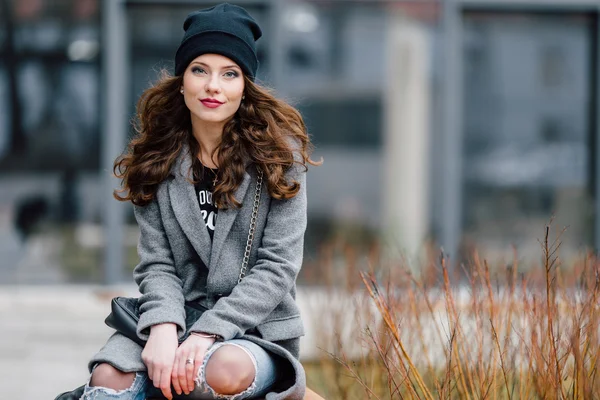 Jeune femme assise dans la rue — Photo