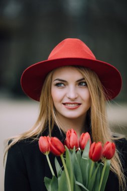 Çiçekli park arka plan üzerinde duran kadın