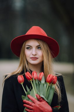 Çiçekli park arka plan üzerinde duran kadın