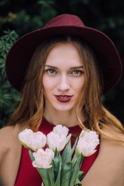 Beyaz çiçeklerle duran güzel kadın