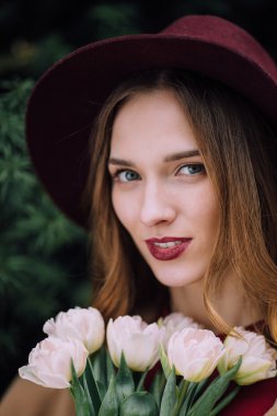 Beyaz çiçeklerle duran güzel kadın