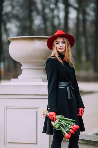 Femme debout sur le fond du parc avec des fleurs — Photo