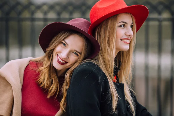 Due ragazze sedute sulla panchina e sorridono — Foto Stock