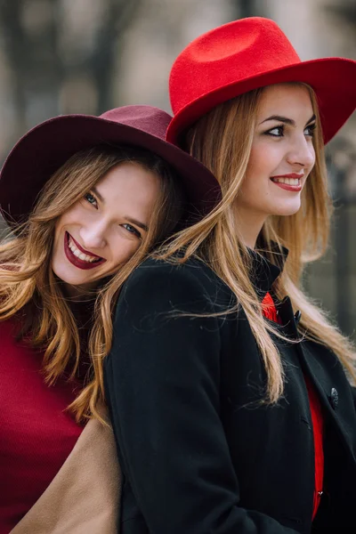 Två tjejer sitter på bänken och leende — Stockfoto