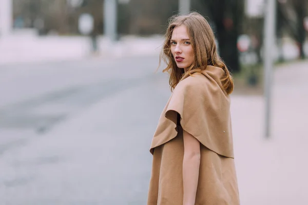 Žena stojí na pozadí park s květinami — Stock fotografie