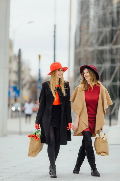 Zwei geschäftige Frauen, die auf der Straße gehen und miteinander reden — Stockfoto