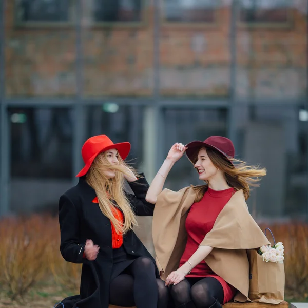 Två upptagen kvinna som sitter på bänken, prata med varandra — Stockfoto