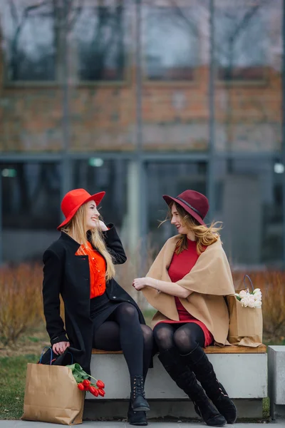 Duas mulheres ocupadas sentadas no banco, conversando umas com as outras — Fotografia de Stock