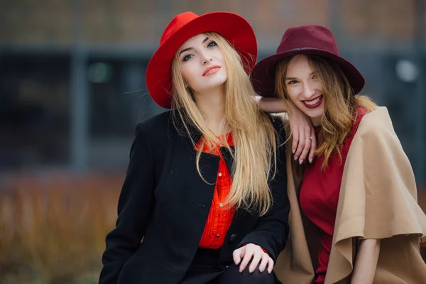 Duas mulheres ocupadas sentadas no banco, conversando umas com as outras — Fotografia de Stock