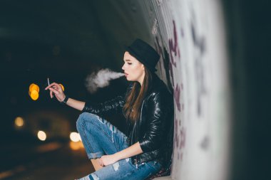 Zemin ve duman üzerinde oturan genç kız