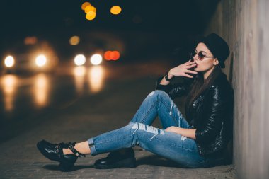 Zemin ve duman üzerinde oturan genç kız