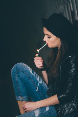 Zemin ve duman üzerinde oturan genç kız