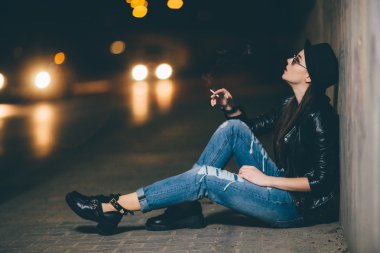 Zemin ve duman üzerinde oturan genç kız