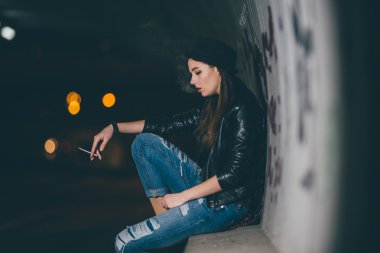 Zemin ve duman üzerinde oturan genç kız