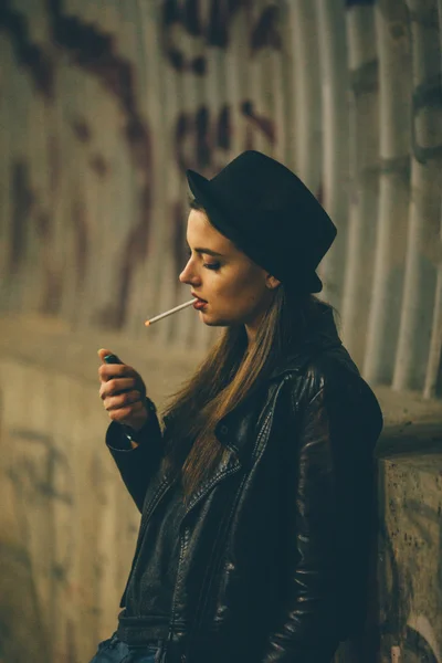 Young girl sitting on the floor and smoke — Stock Photo, Image