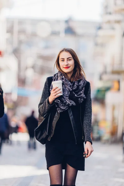 Giovane ragazza che cammina per strada con una tazza di caffè caldo — Foto Stock
