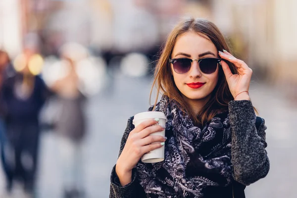 Jeune fille marchant dans la rue avec une tasse de café chaud — Photo