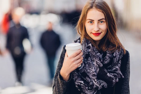 Jong meisje lopen op de straat met een kop warme koffie — Stockfoto