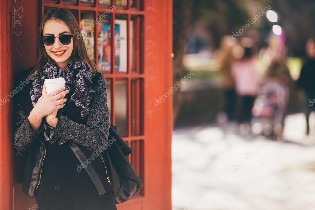 Beautiful girl standing in front of call box