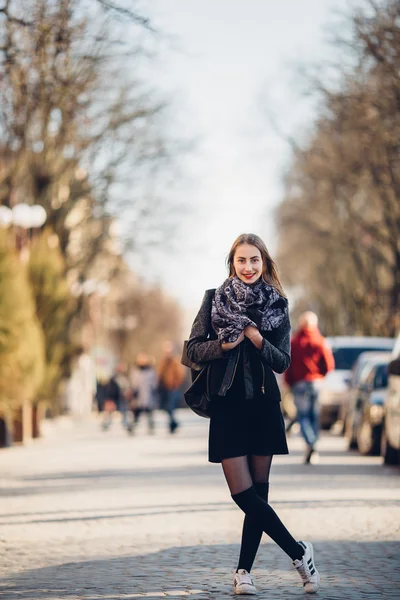 Flickan står på gatan med solnedgång bakgrund — Stockfoto