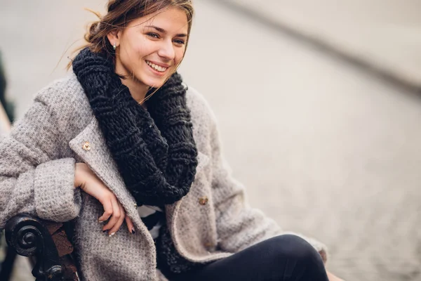 Vacker kvinna som sitter på bänken och smile — Stockfoto