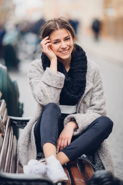 Bella donna seduta sulla panchina e sorridere — Foto Stock