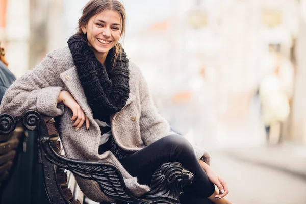 Vacker kvinna som sitter på bänken och smile — Stockfoto