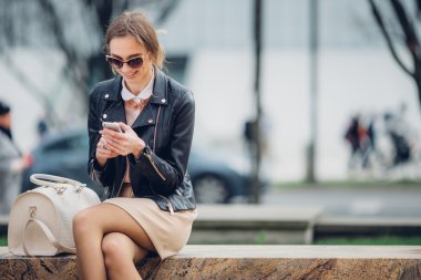 Güzel kadın bankta oturan telefonunu söz