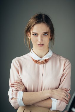 Gri arka plan önünde duran güzel kadın