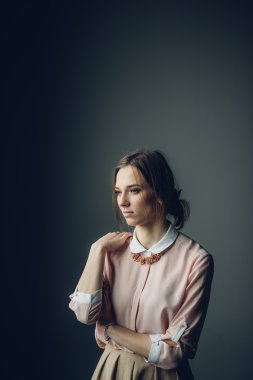 Gri arka plan önünde duran güzel kadın