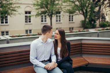 Park arka planda oturan güzel Çift