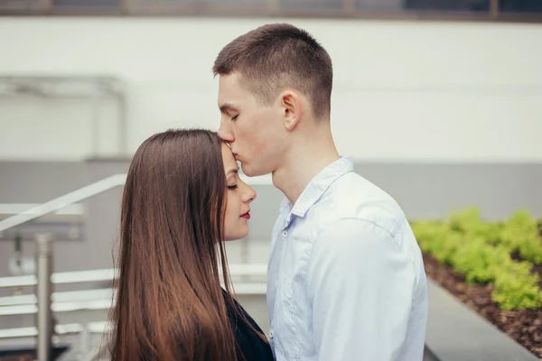 Encantador casal de pé na rua e beijando — Fotografia de Stock