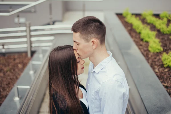 Encantador casal de pé na rua e beijando — Fotografia de Stock