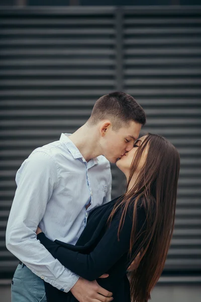 Encantador casal de pé na rua e beijando — Fotografia de Stock