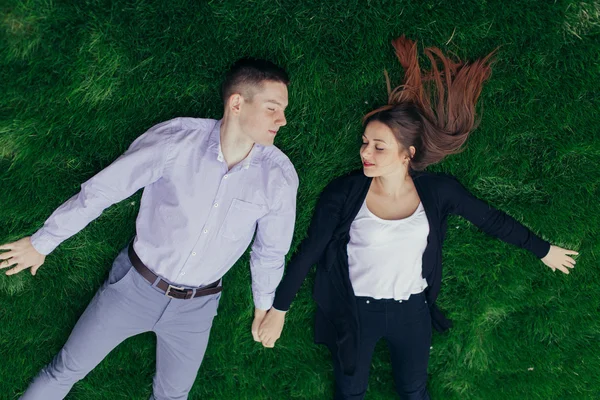 Preciosa pareja acostada en la hierba y sonriendo —  Fotos de Stock
